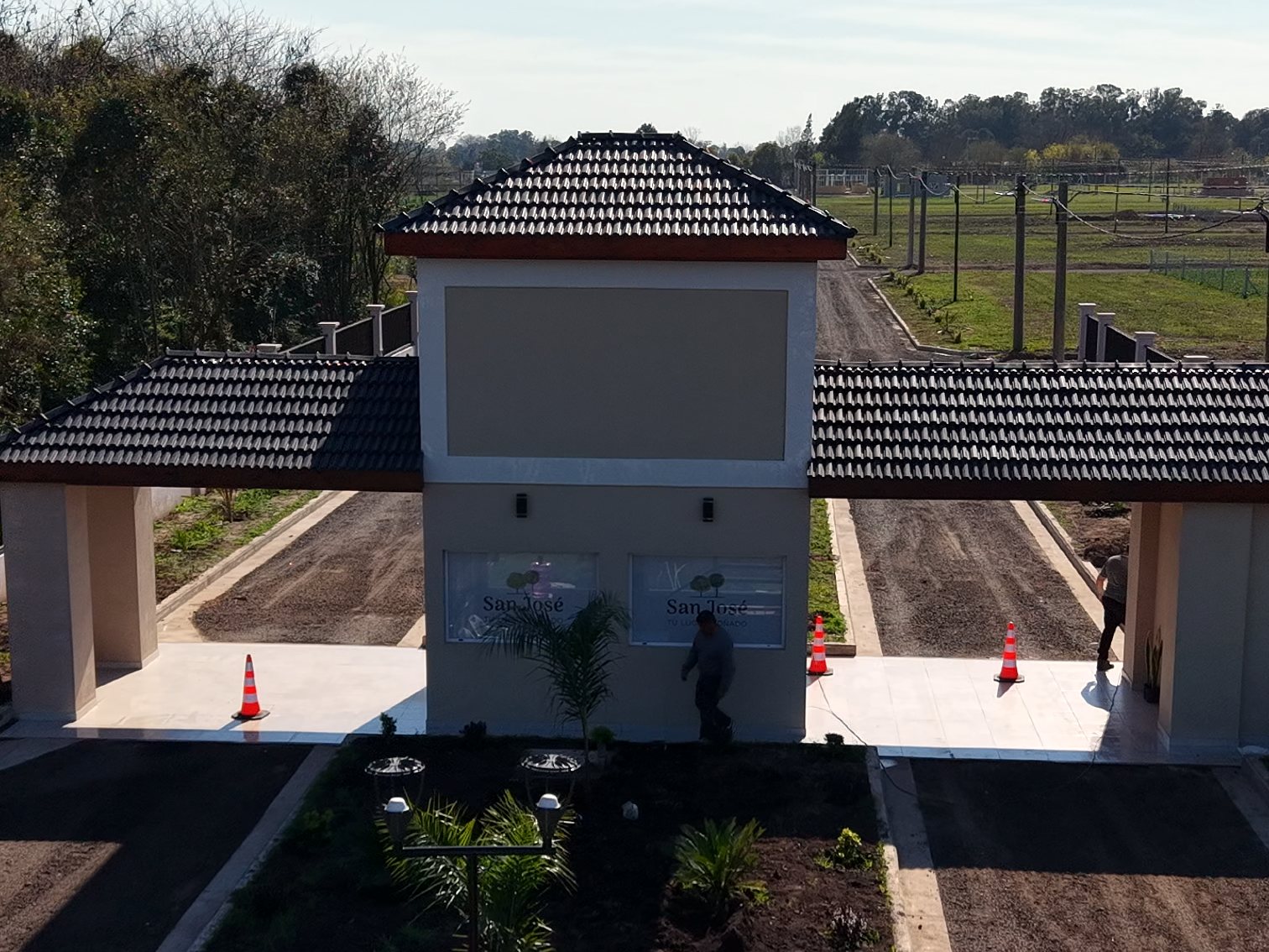 Garita de acceso de San José VI con canteros y flores, septiembre 2026